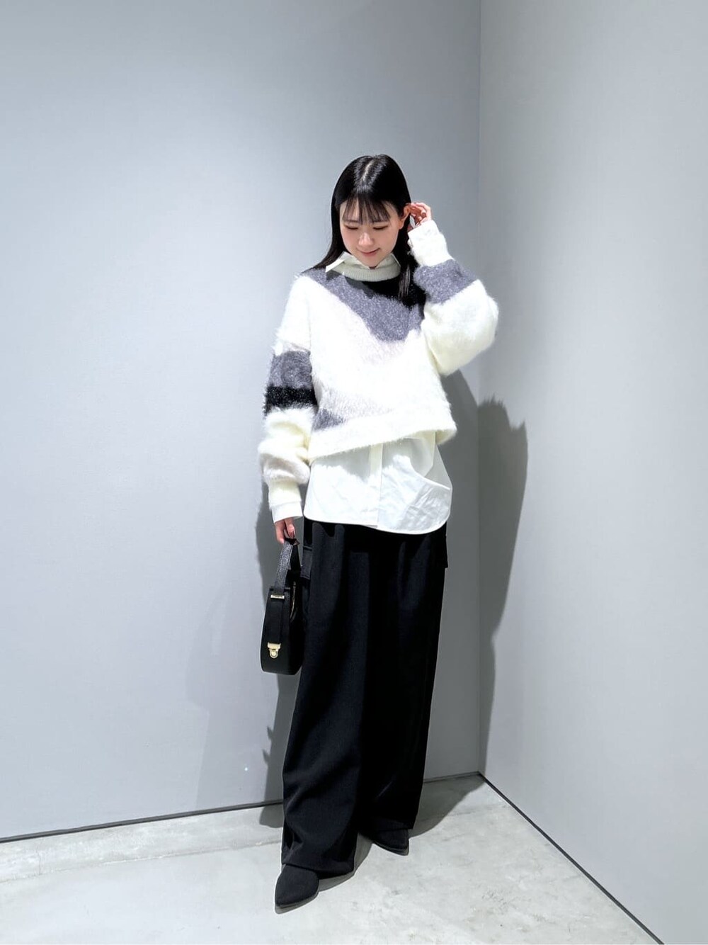 ホワイト系のニット/セーター、ホワイト系のシャツ/ブラウス、ブラック系のその他パンツを着用したレディースの冬コーディネートの4枚目の写真