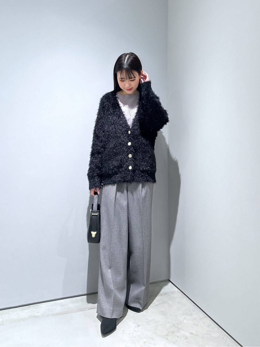 ブラック系のカーディガン/ボレロ、ブラック系のその他パンツ、ブラック系のショルダーバッグを着用したレディースの冬コーディネートの4枚目の写真