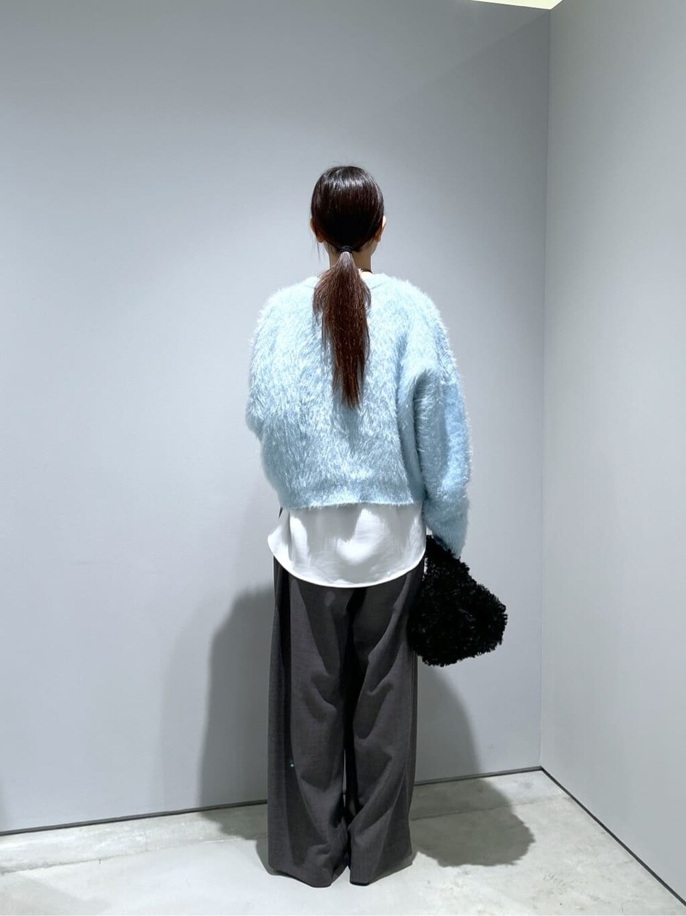 ブルー系のニット/セーター、ホワイト系のシャツ/ブラウス、グレー系のその他パンツを着用したレディースの秋コーディネートの6枚目の写真