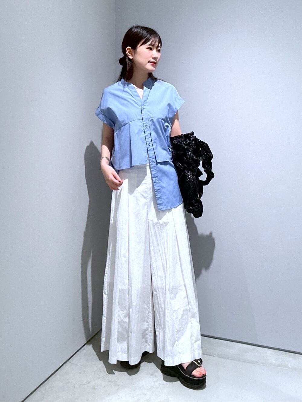 ブルー系のシャツ/ブラウス、ホワイト系のその他パンツ、ブラック系のトートバッグを着用したレディースの夏コーディネートの4枚目の写真
