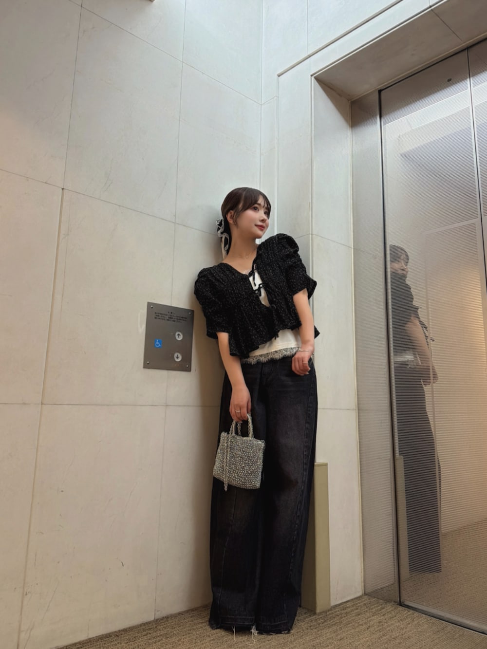 ブラック系のデニムパンツ、ブラック系のシャツ/ブラウス、ホワイト系のキャミソールを着用したレディースの夏コーディネートの2枚目の写真
