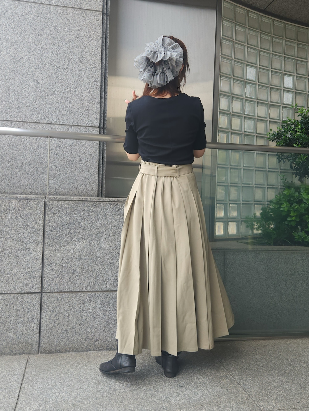 ブラック系のTシャツ/カットソー、ベージュ系のスカートを着用したレディースの夏コーディネートの3枚目の写真