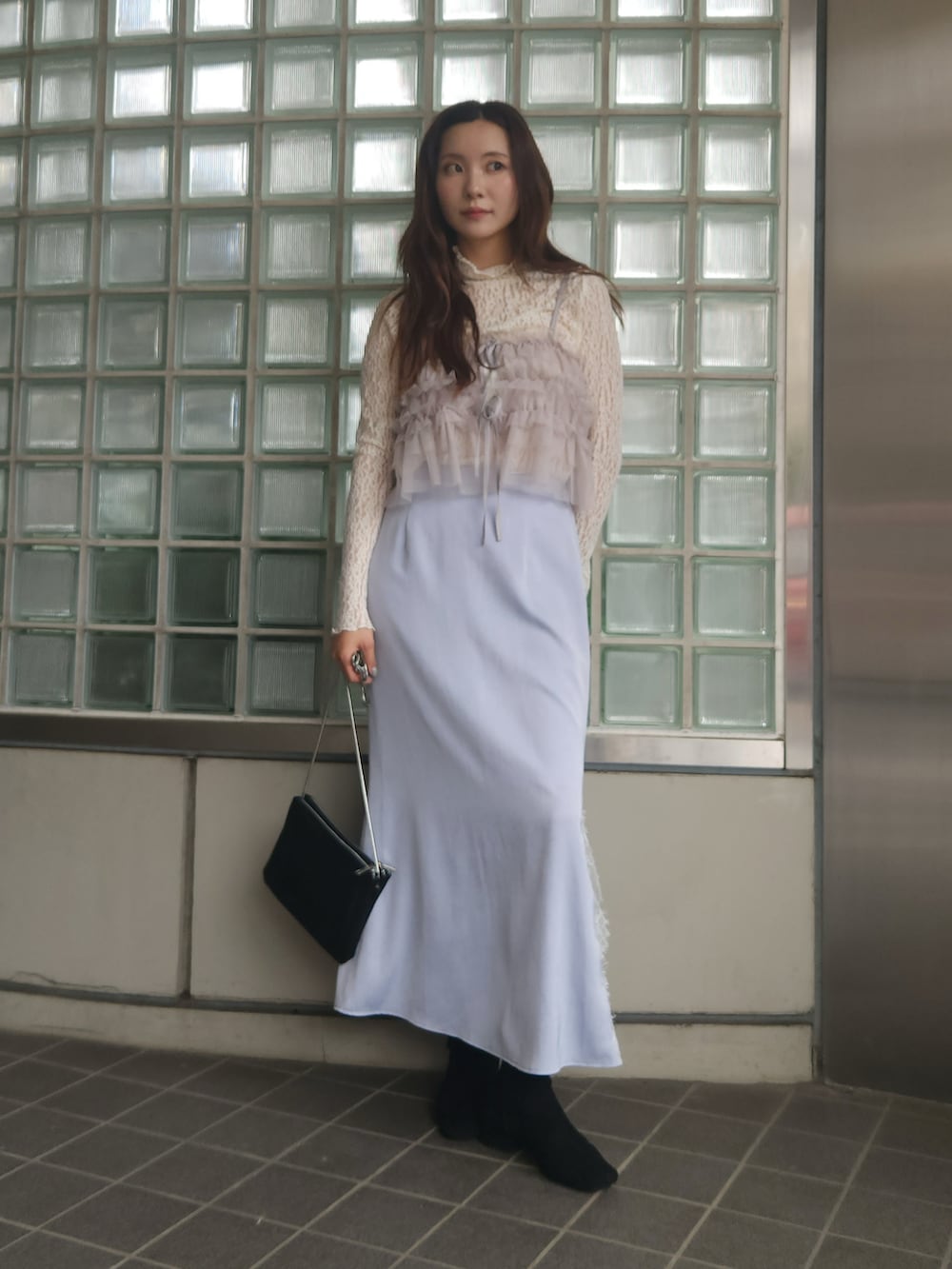 ベージュ系のTシャツ/カットソー、グレー系のキャミソール、ブルー系のスカートを着用したレディースの秋コーディネートの2枚目の写真