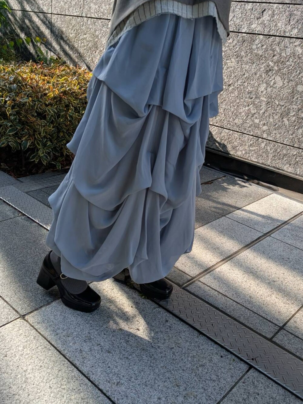 グレー系のスカートを着用したレディースの春コーディネートの2枚目の写真