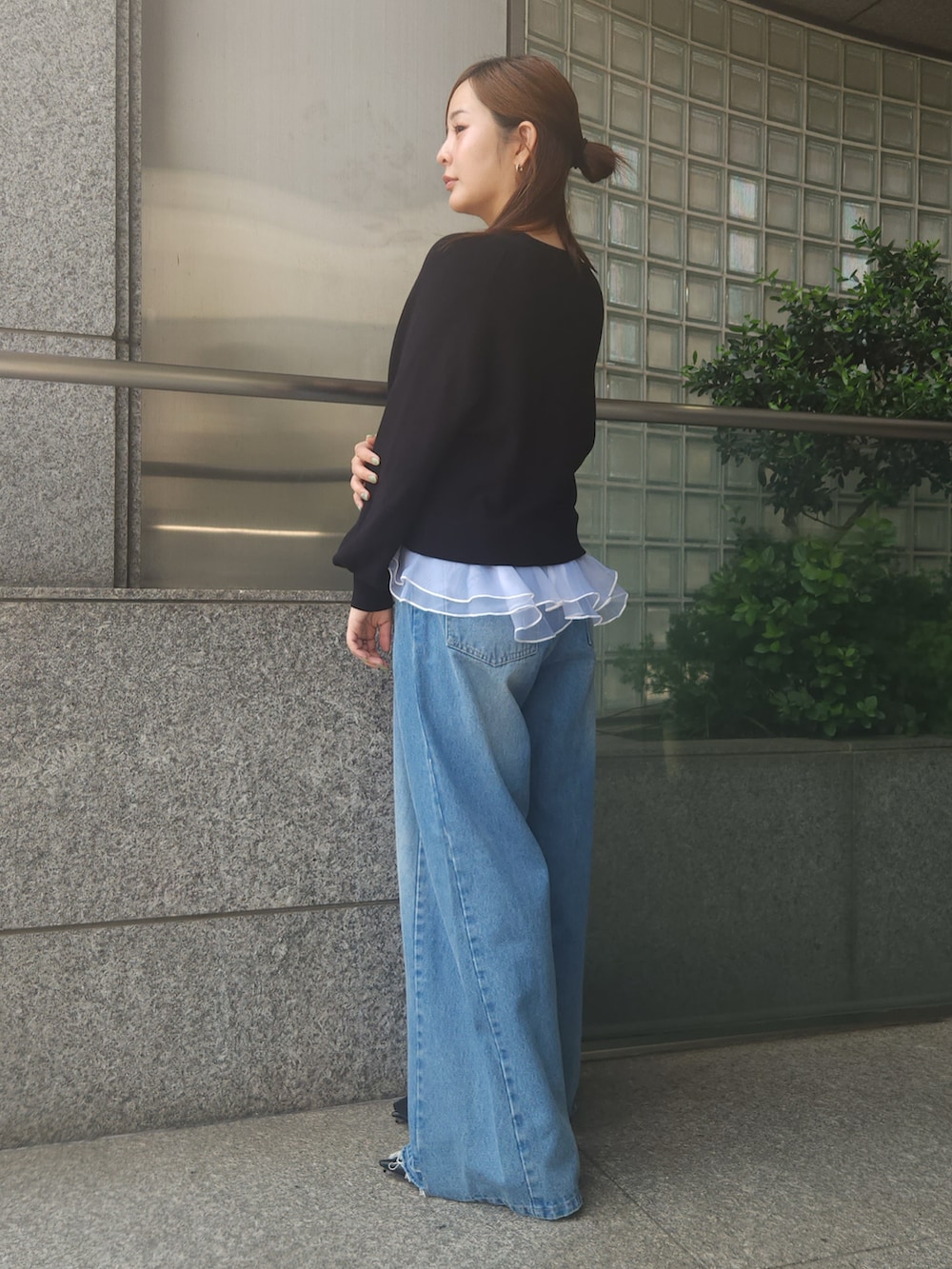 ブルー系のデニムパンツ、ブラック系のニット/セーターを着用したレディースの秋コーディネートの2枚目の写真