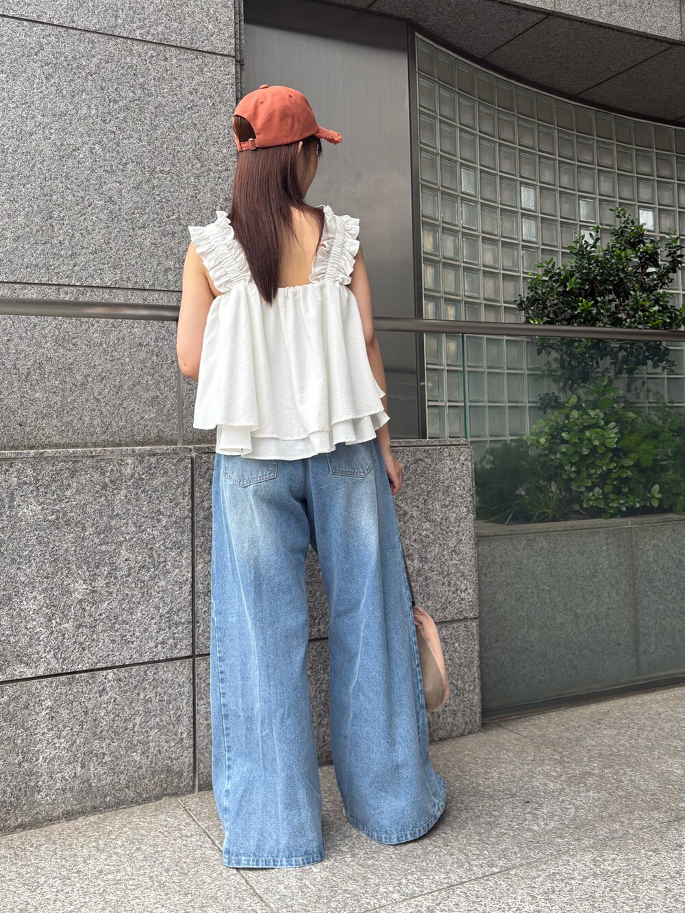 ブルー系のデニムパンツ、ホワイト系のタンクトップを着用したレディースの夏コーディネートの3枚目の写真