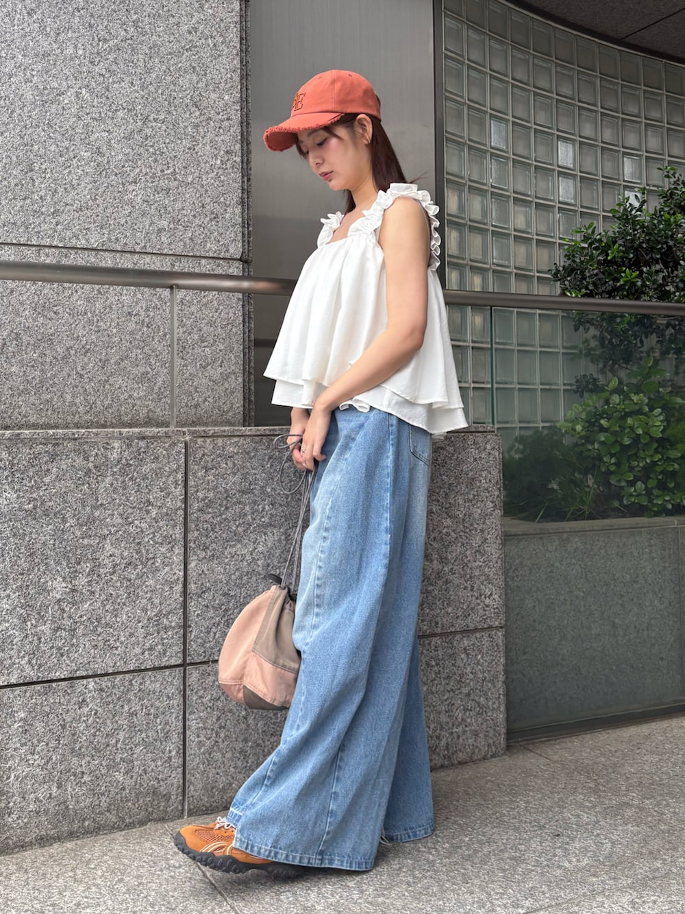 ブルー系のデニムパンツ、ホワイト系のタンクトップを着用したレディースの夏コーディネートの2枚目の写真