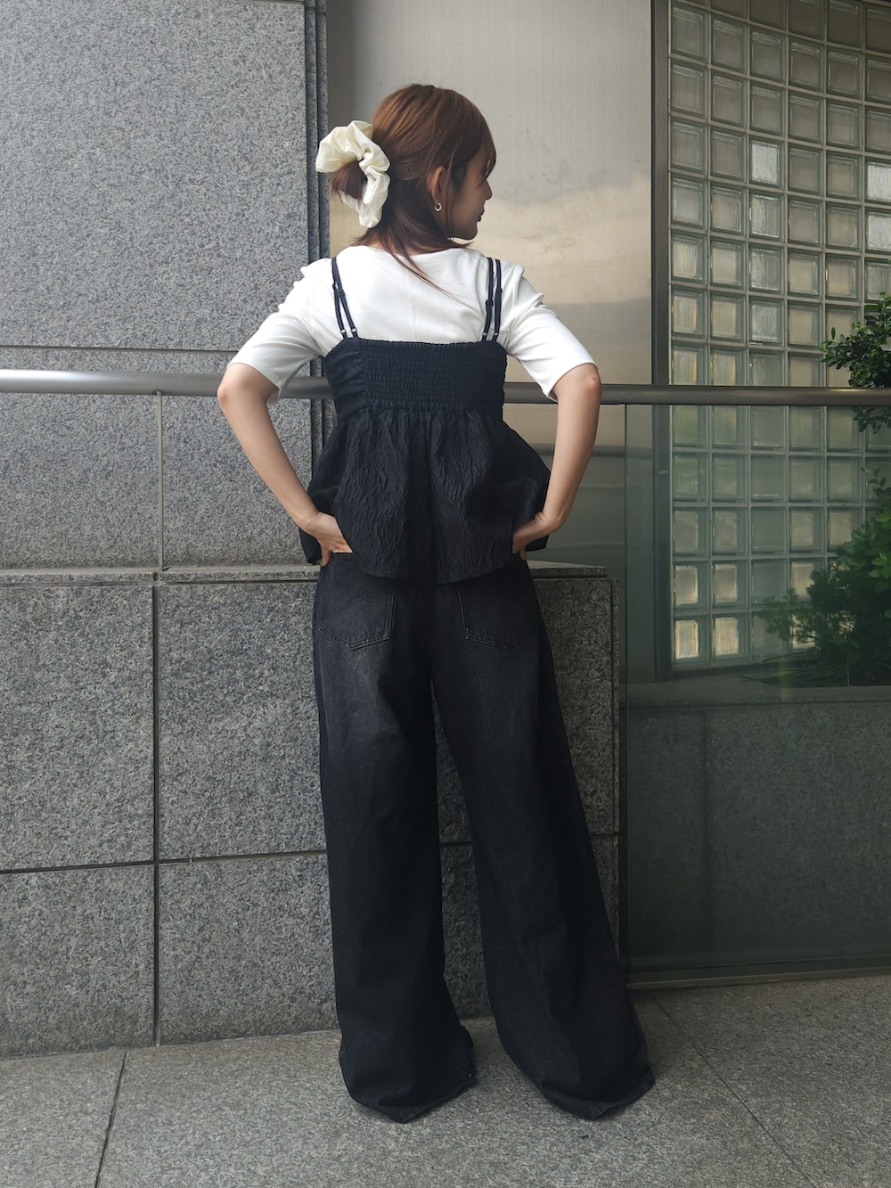 ブラック系のキャミソール、ブラック系のデニムパンツ、ホワイト系のTシャツ/カットソーを着用したレディースの夏コーディネートの2枚目の写真