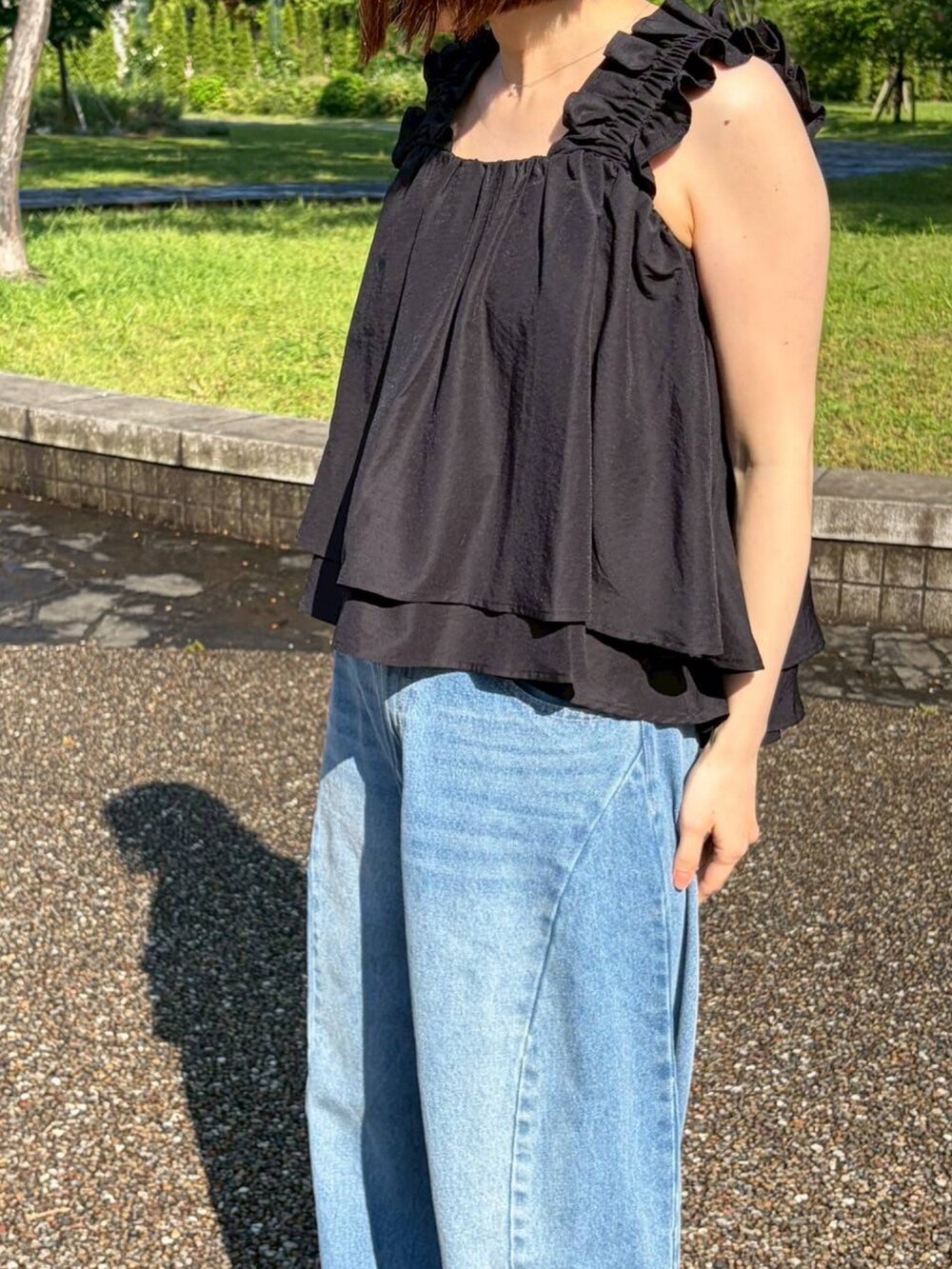 ブルー系のデニムパンツ、ブラック系のシャツ/ブラウスを着用したレディースの春コーディネートの2枚目の写真