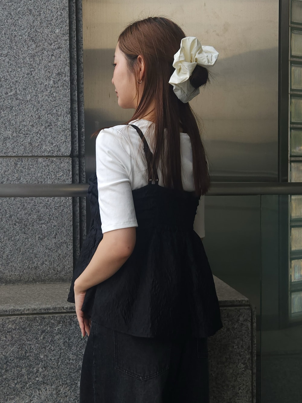 ブラック系のキャミソール、ブラック系のデニムパンツ、ホワイト系のTシャツ/カットソーを着用したレディースの夏コーディネートの4枚目の写真