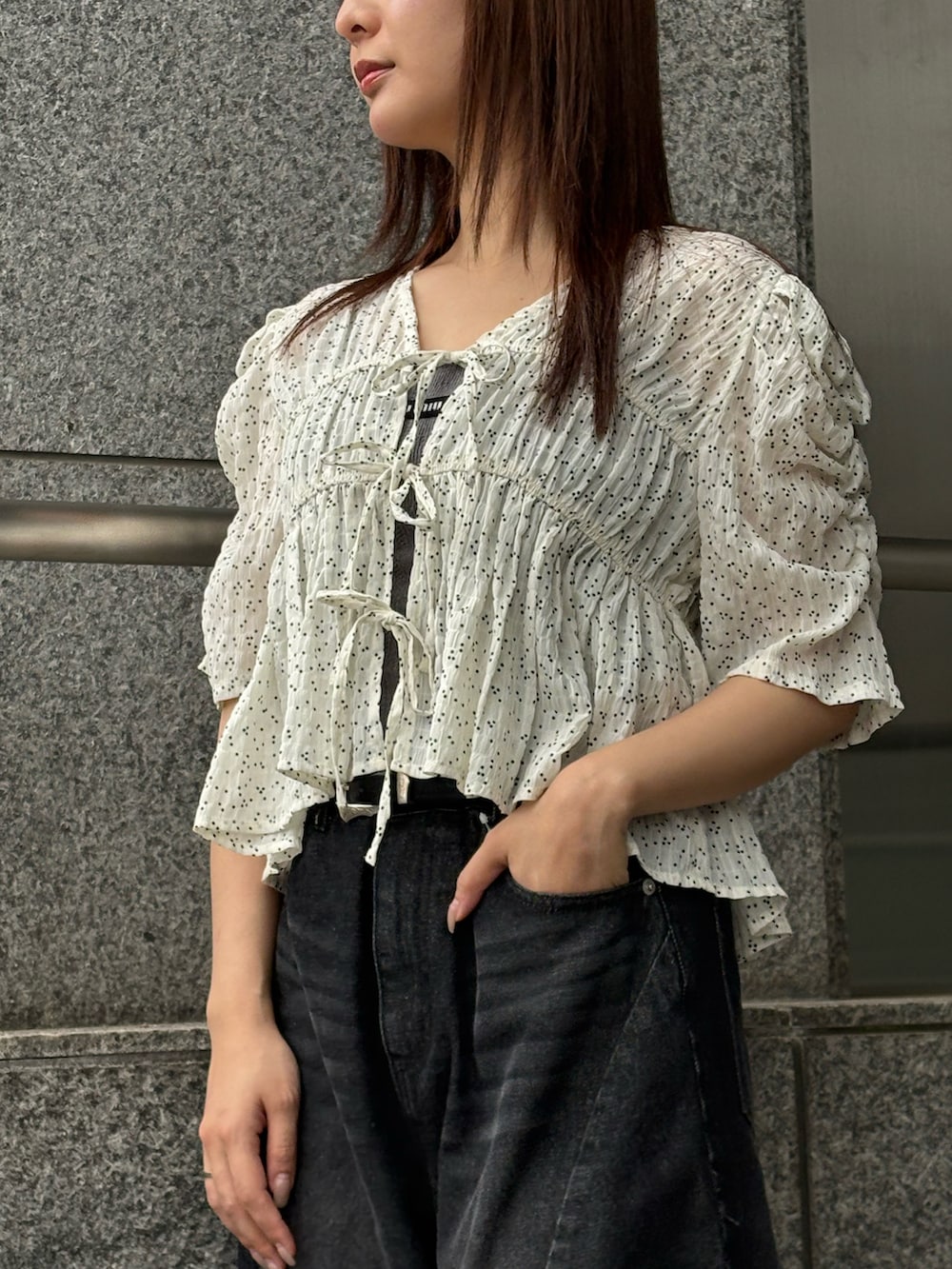 ブラック系のデニムパンツ、ホワイト系のシャツ/ブラウスを着用したレディースの夏コーディネートの3枚目の写真