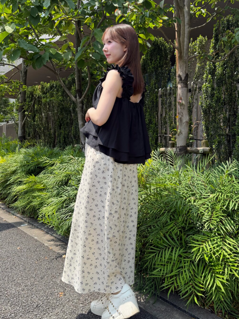 ブラック系のタンクトップ、ホワイト系のスカートを着用したレディースの春コーディネートの2枚目の写真