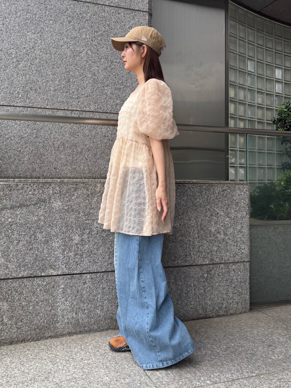ベージュ系のシャツ/ブラウス、ブルー系のデニムパンツを着用したレディースの夏コーディネートの2枚目の写真