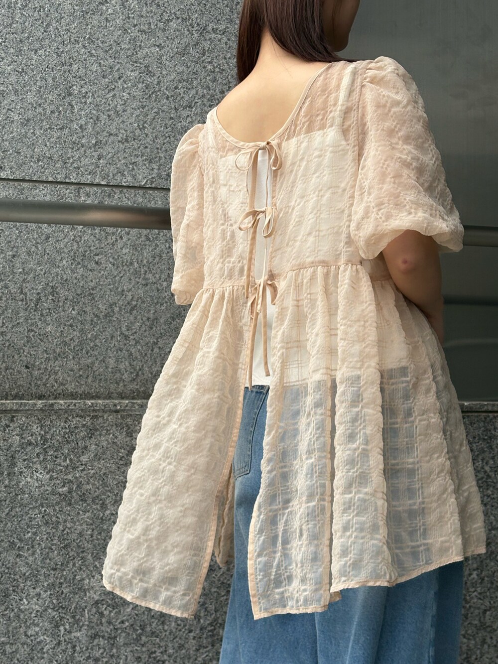 ベージュ系のシャツ/ブラウス、ブルー系のデニムパンツを着用したレディースの夏コーディネートの4枚目の写真