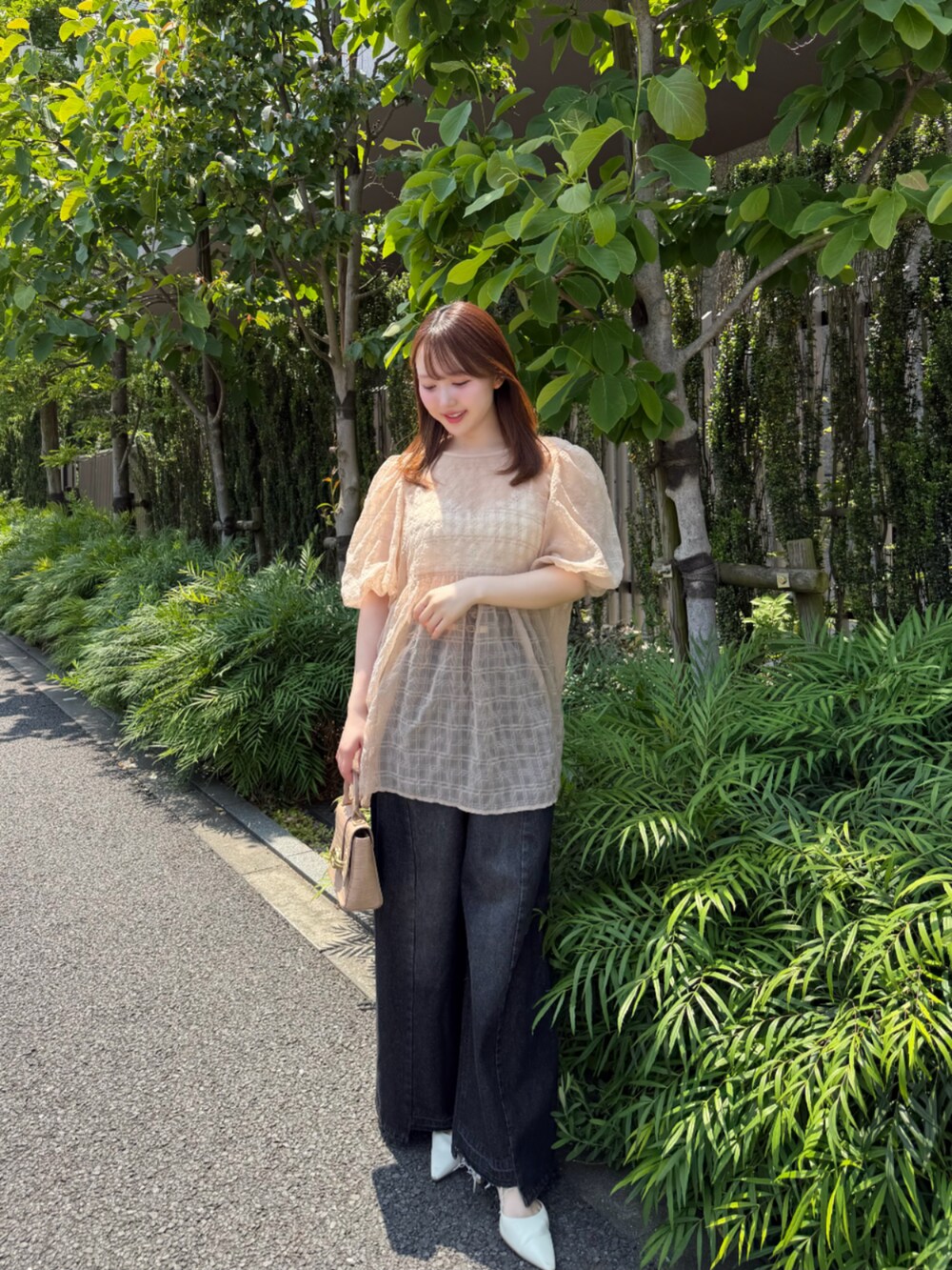 ブラック系のデニムパンツ、ベージュ系のシャツ/ブラウスを着用したレディースの春コーディネートの3枚目の写真