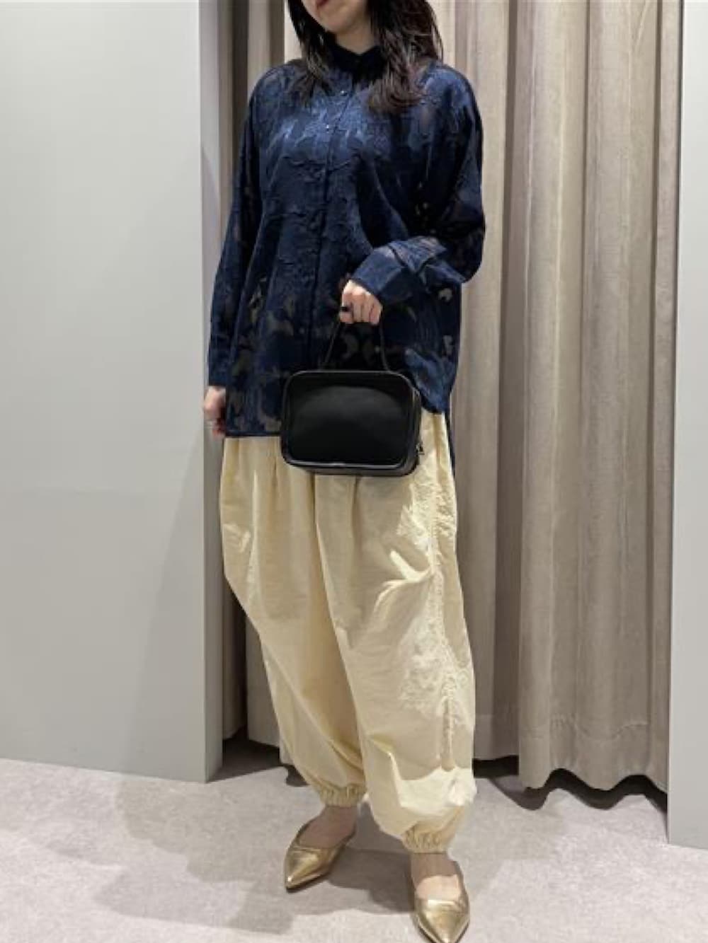 ブルー系のシャツ/ブラウス、ブラック系のハンドバッグを着用したレディースの冬コーディネートの2枚目の写真