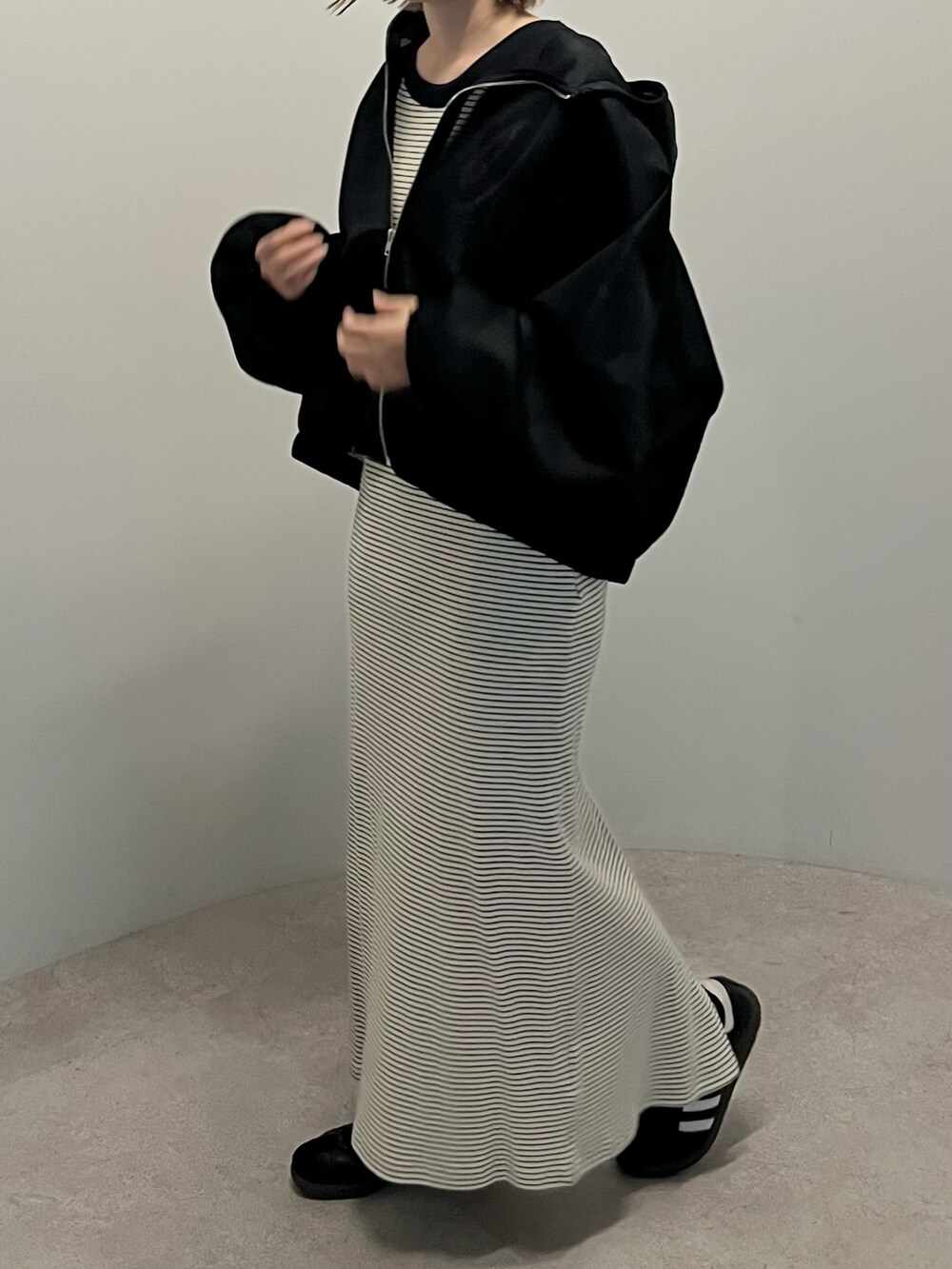 ブラック系のパーカーを着用したレディースの春コーディネートの2枚目の写真