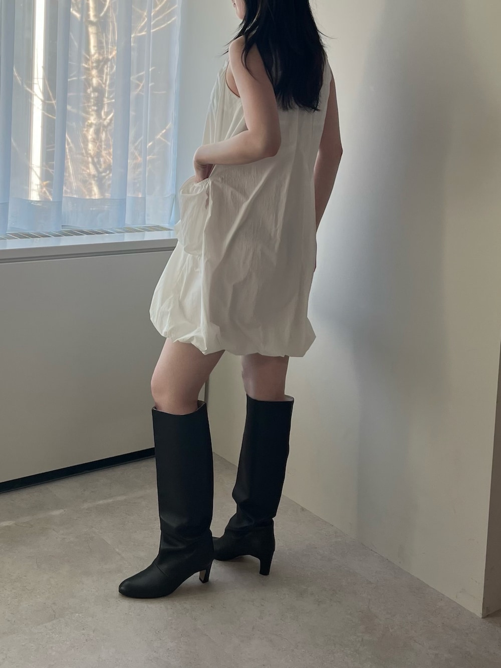 ホワイト系のチュニックを着用したレディースの冬コーディネートの2枚目の写真