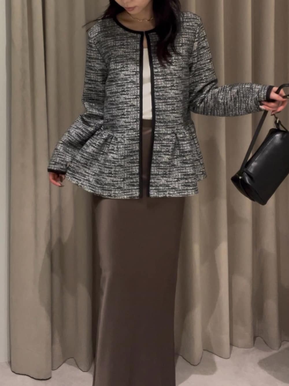 ブラック系のスーツセット、ブラック系のハンドバッグを着用したレディースの冬コーディネートの2枚目の写真