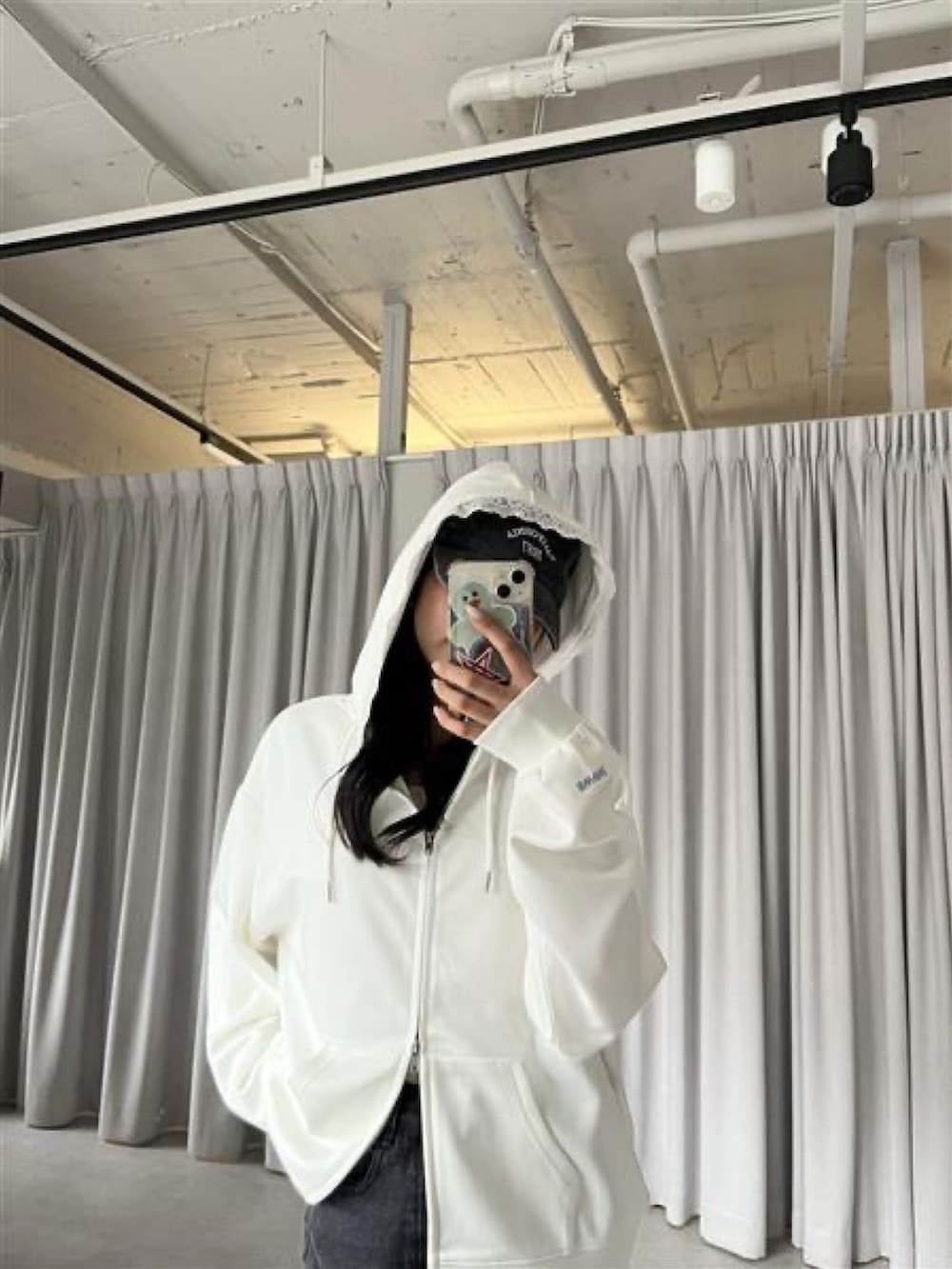 ホワイト系のパーカーを着用したレディースの春コーディネートの3枚目の写真