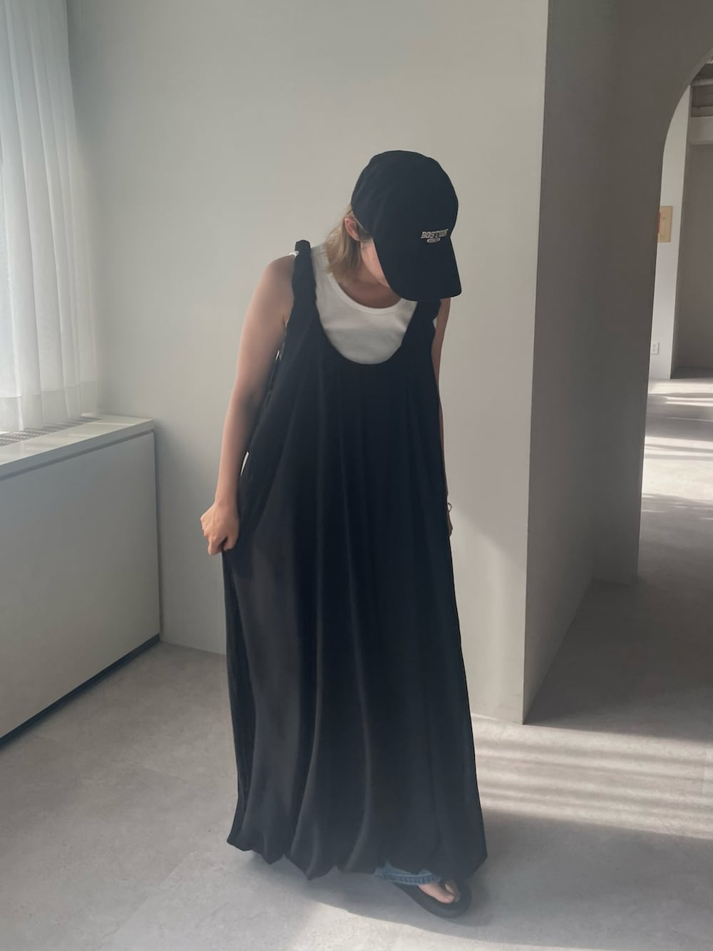 ブラック系のワンピース、ホワイト系のタンクトップを着用したレディースの春コーディネートの2枚目の写真