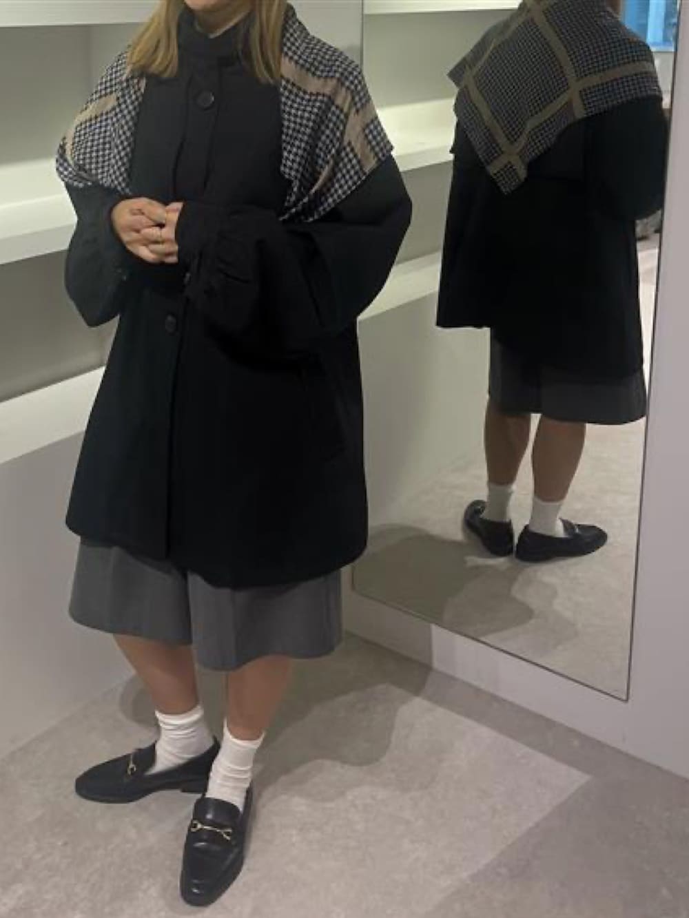 ブラック系のトレンチコートを着用したレディースの冬コーディネートの2枚目の写真