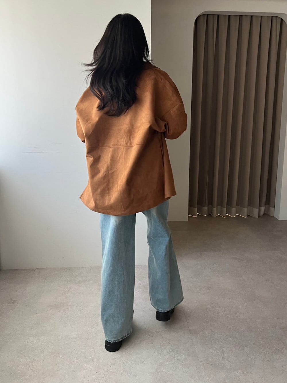 ブラウン系のシャツ/ブラウス、ホワイト系のベスト、ブルー系のデニムパンツを着用したレディースの冬コーディネートの2枚目の写真