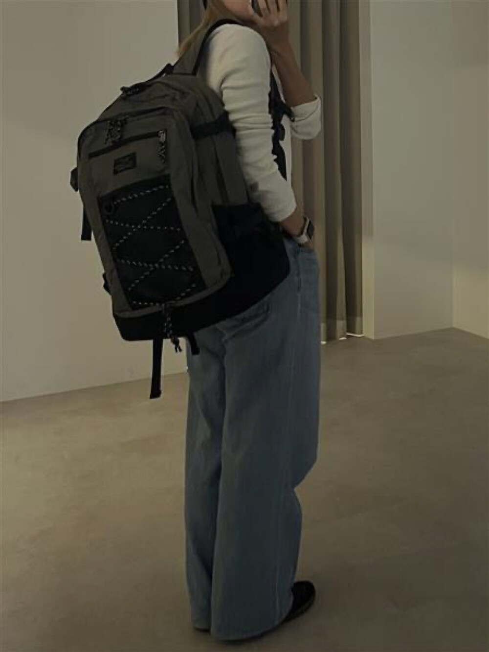 グレー系のバックパック/リュック、ホワイト系のTシャツ/カットソーを着用したレディースの冬コーディネートの2枚目の写真