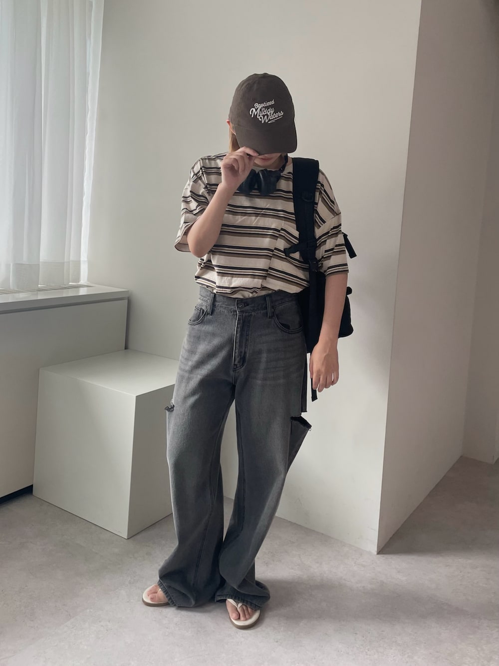ブラック系のバックパック/リュック、ベージュ系のTシャツ/カットソーを着用したレディースの夏コーディネートの2枚目の写真