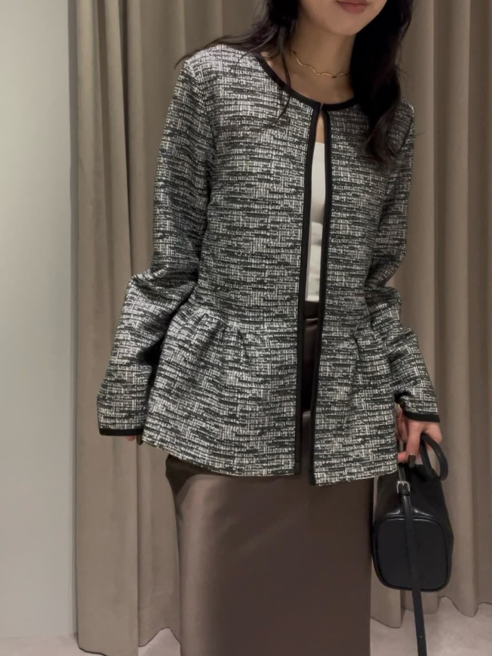 ブラック系のスーツセット、ブラック系のハンドバッグを着用したレディースの冬コーディネートの3枚目の写真