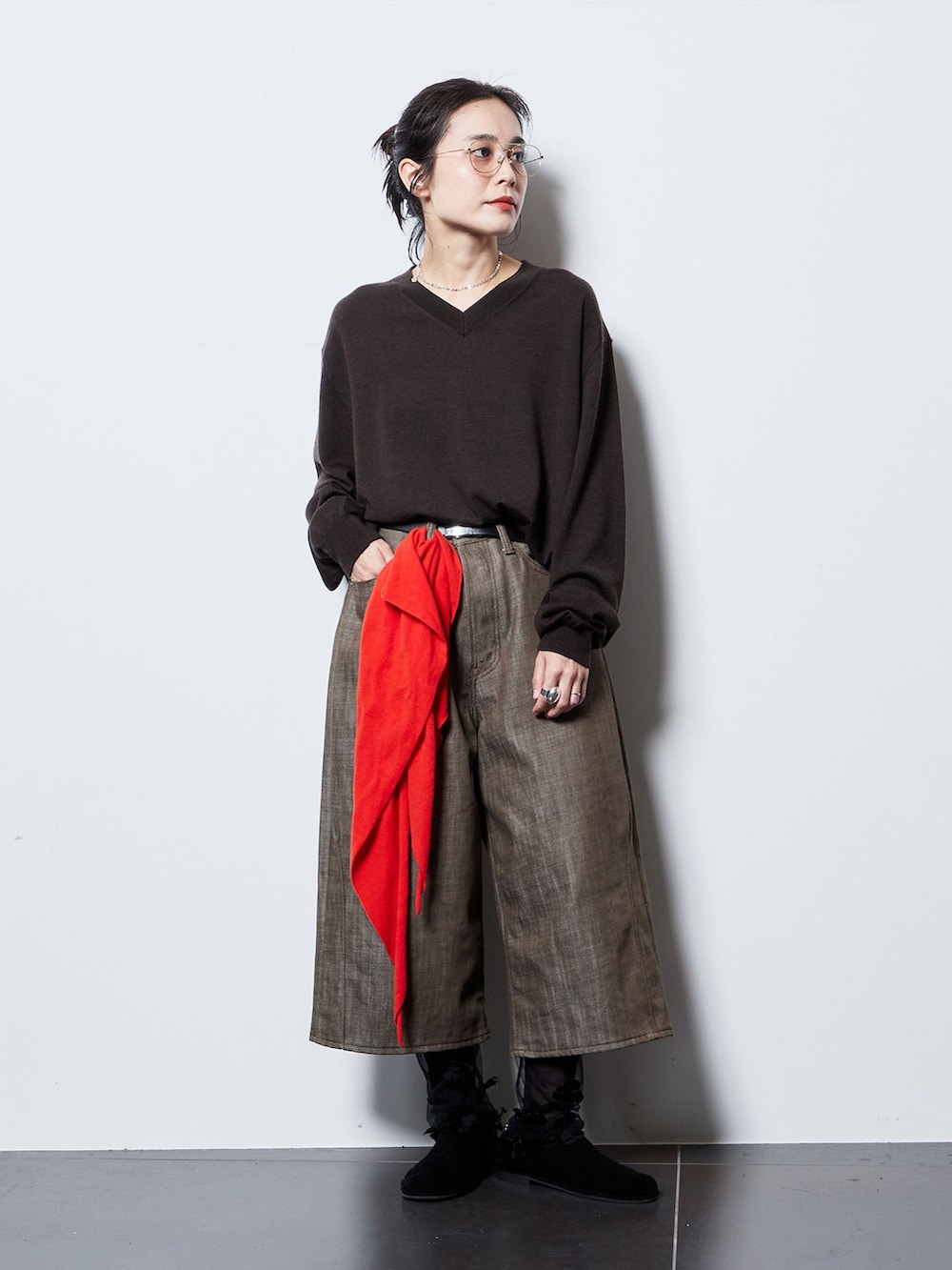 ブラック系のその他アウター、ブラウン系のデニムパンツ、ブラウン系のニット/セーターを着用したレディースの秋コーディネートの2枚目の写真