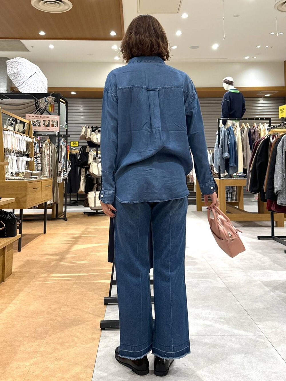 ブルー系のデニムパンツ、ブルー系のシャツ/ブラウス、ピンク系のハンドバッグを着用したレディースの冬コーディネートの4枚目の写真