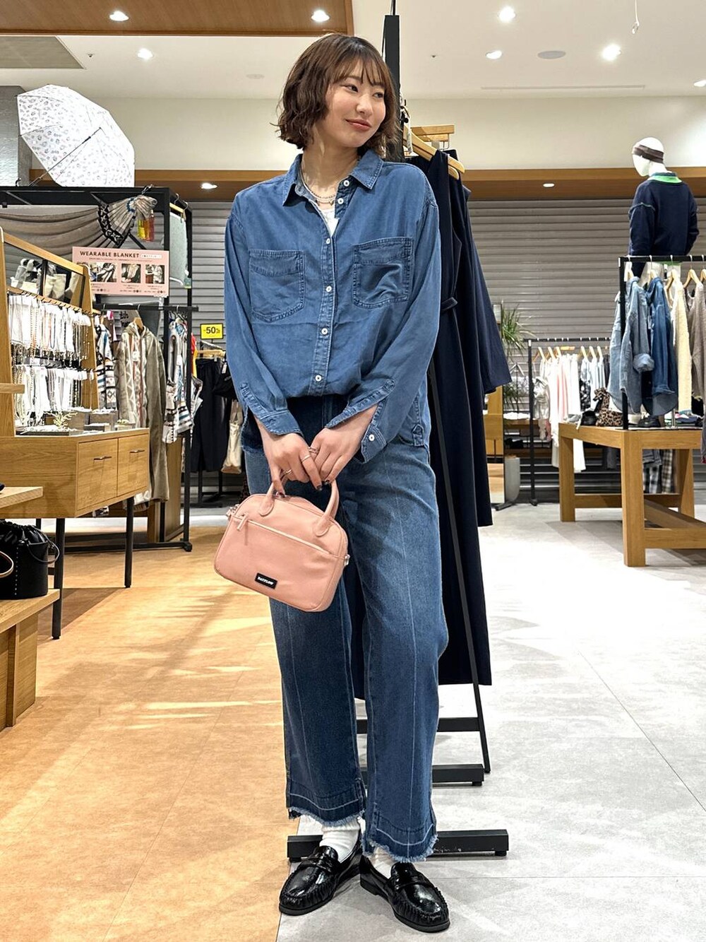 ブルー系のデニムパンツ、ブルー系のシャツ/ブラウス、ピンク系のハンドバッグを着用したレディースの冬コーディネートの2枚目の写真