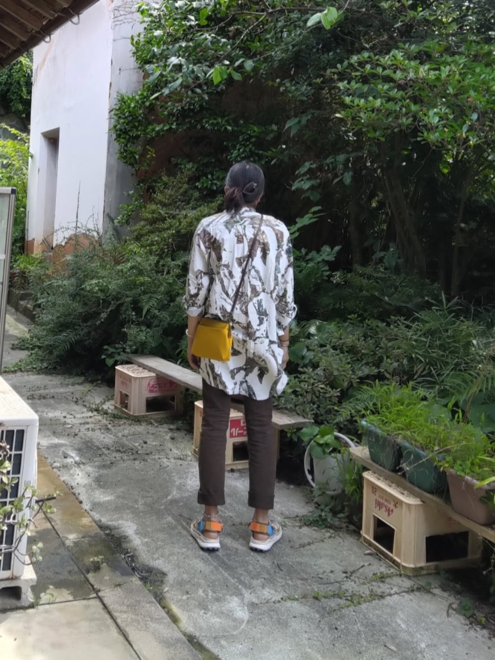 イエロー系のサンダル、ブラウン系のデニムパンツを着用したメンズの夏コーディネートの3枚目の写真