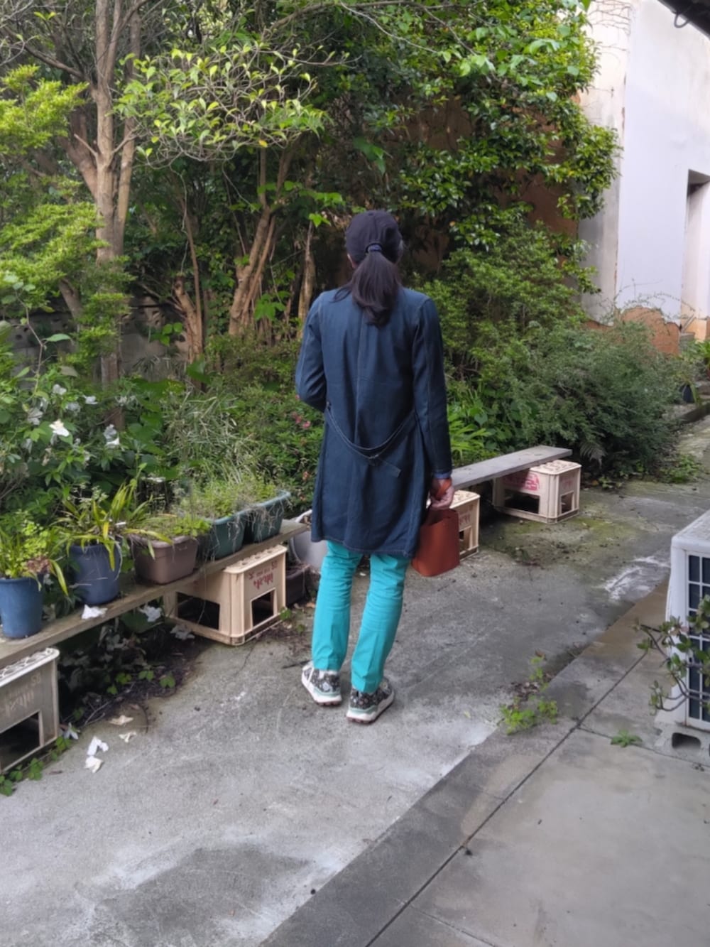 ブルー系のスニーカー、グリーン系のチノパンツ、ブルー系のステンカラーコートを着用したメンズの春コーディネートの2枚目の写真
