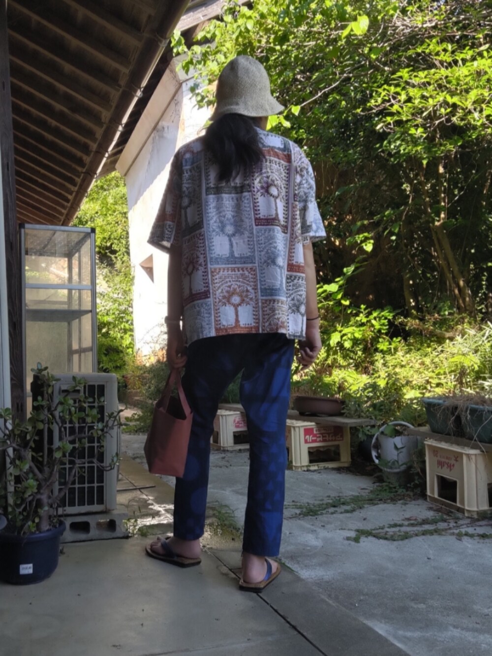 ブラウン系のトートバッグ、ブルー系のその他パンツ、その他のその他シューズを着用したメンズの夏コーディネートの3枚目の写真
