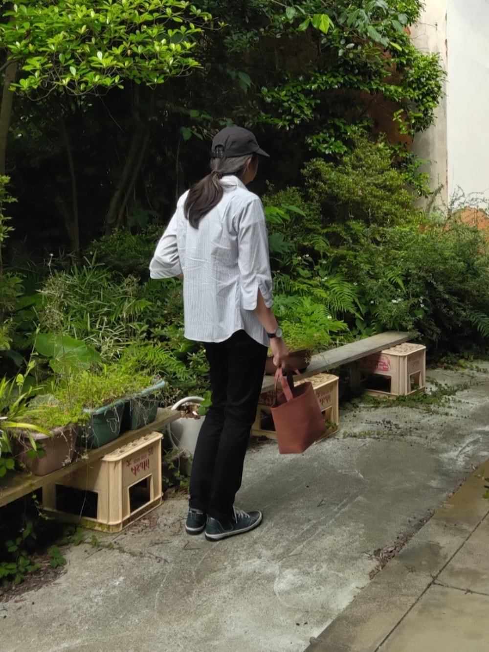 ブラック系のデニムパンツ、ブルー系のスニーカー、ホワイト系のTシャツ/カットソーを着用したメンズの夏コーディネートの2枚目の写真