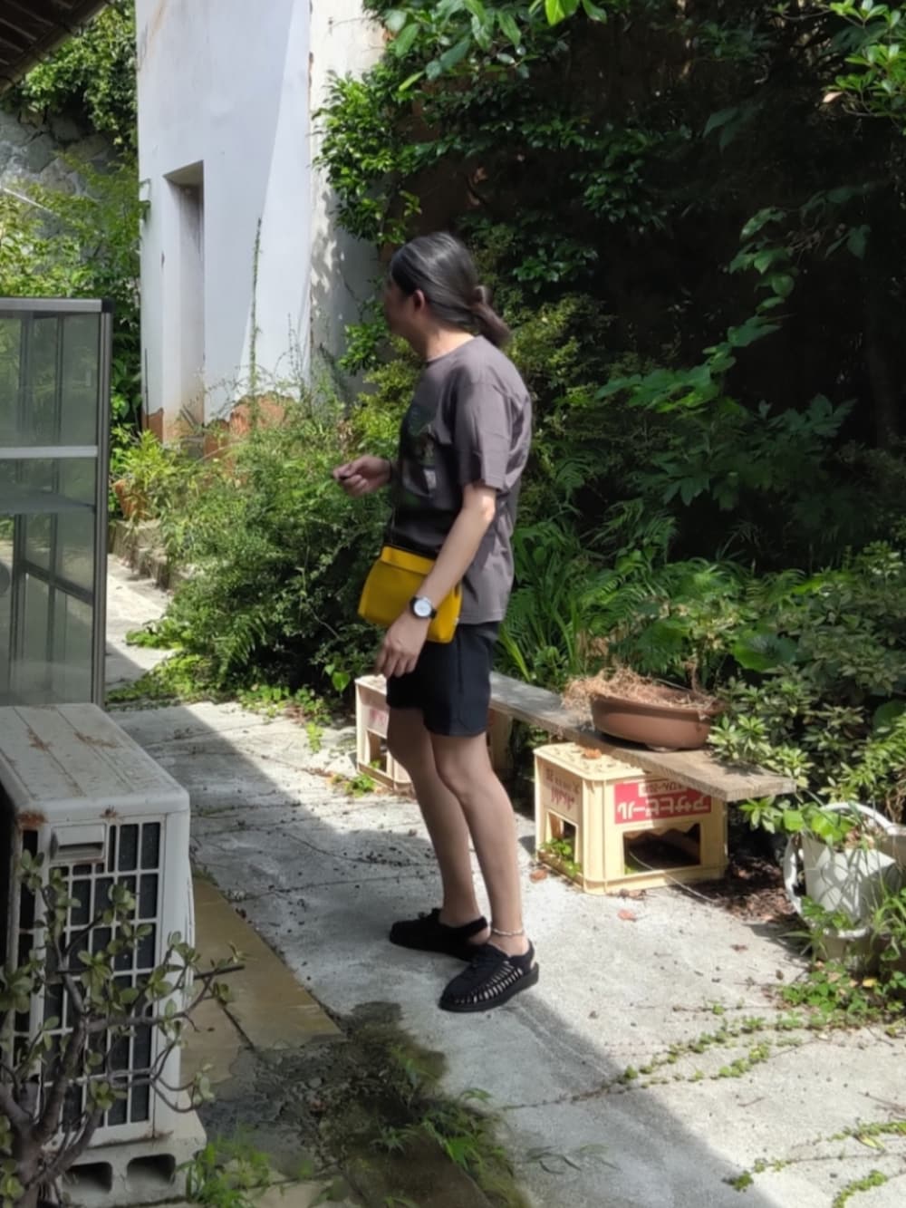 グレー系のTシャツ/カットソー、イエロー系のショルダーバッグ、ブラック系のデニムパンツを着用したメンズの夏コーディネートの2枚目の写真