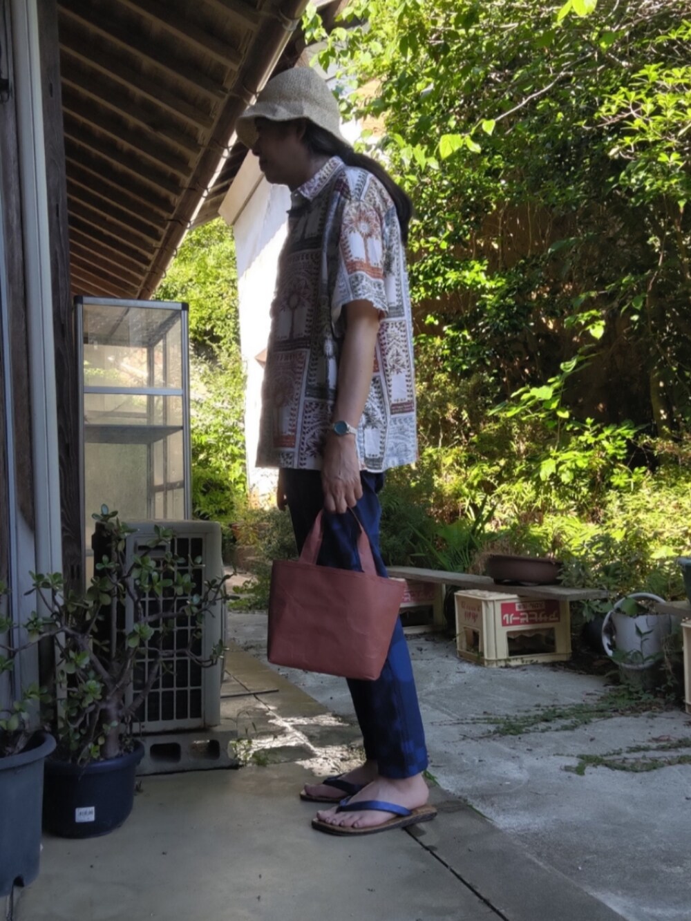 ブラウン系のトートバッグ、ブルー系のその他パンツ、その他のその他シューズを着用したメンズの夏コーディネートの2枚目の写真