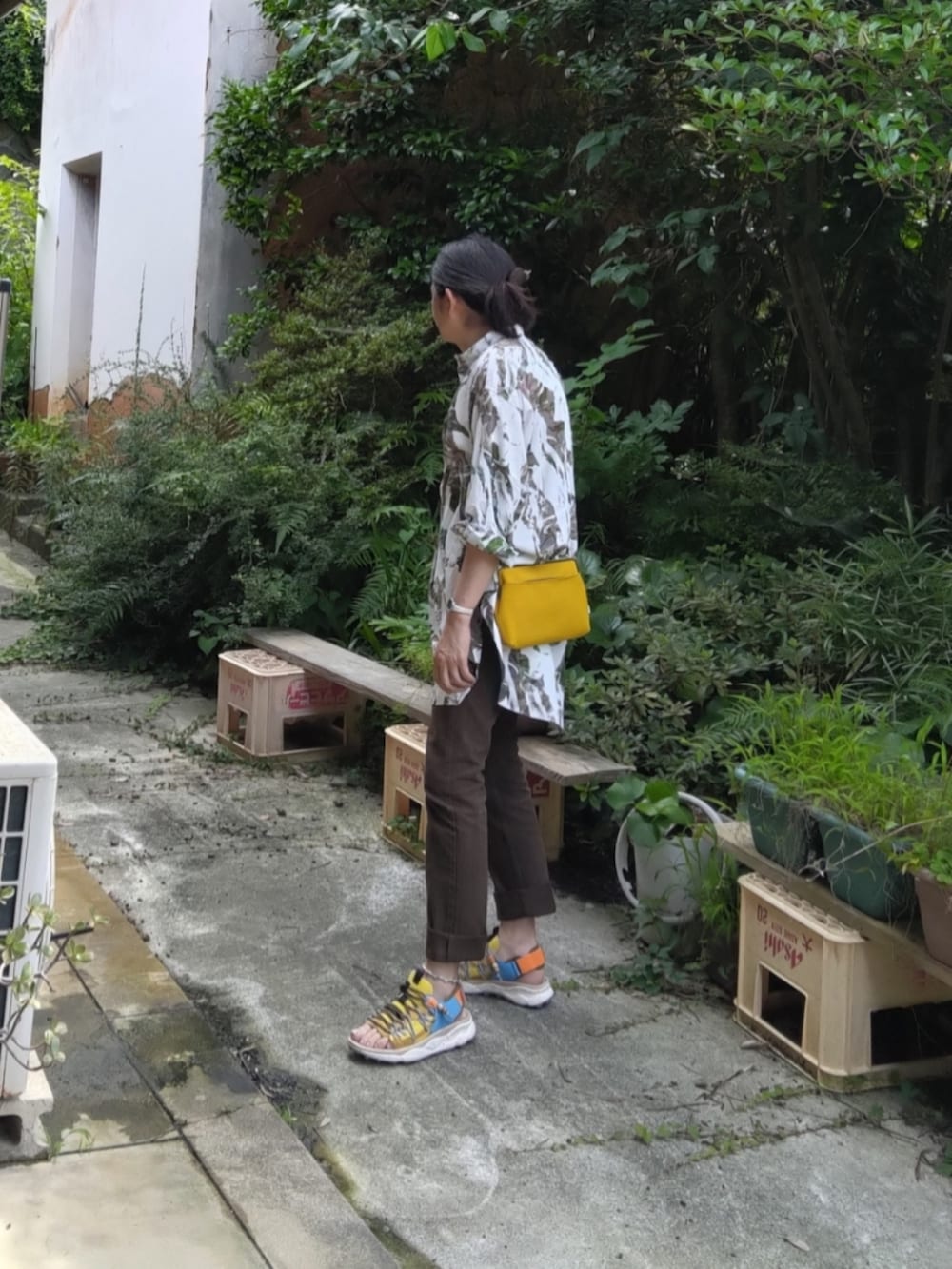イエロー系のサンダル、ブラウン系のデニムパンツを着用したメンズの夏コーディネートの2枚目の写真
