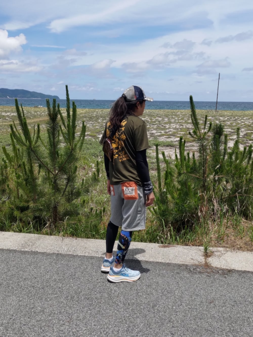 ブルー系のその他シューズ、グレー系のスウェットパンツ、グリーン系のTシャツ/カットソーを着用したメンズの夏コーディネートの2枚目の写真