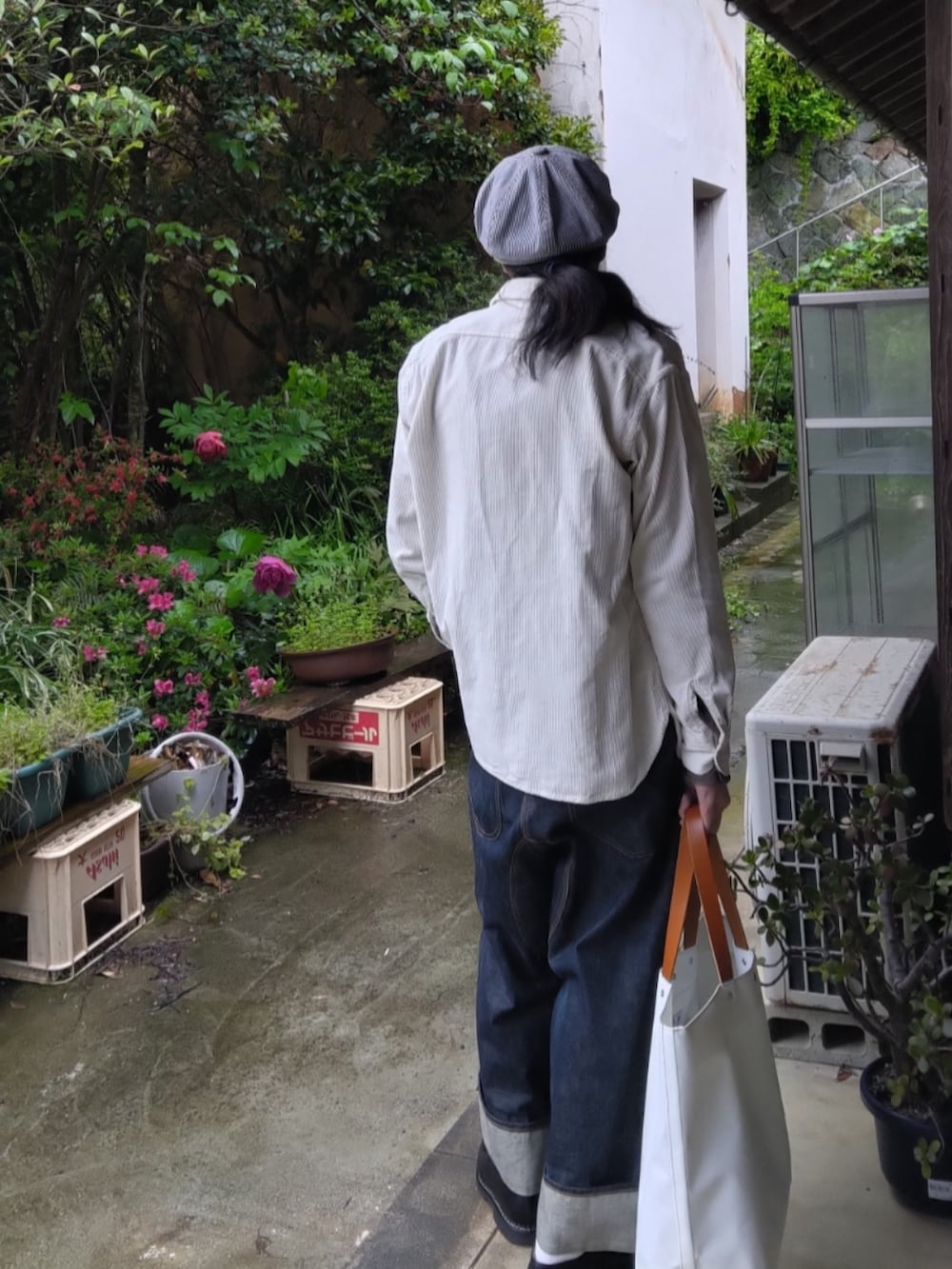 ブルー系のサロペット/オーバーオール、ホワイト系のトートバッグ、ブラック系のモカシン/デッキシューズを着用したメンズの春コーディネートの2枚目の写真