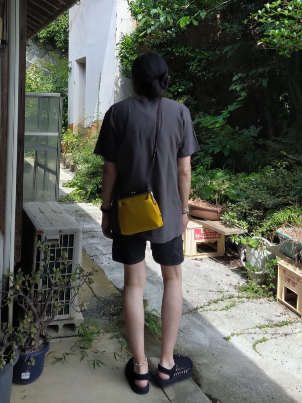グレー系のTシャツ/カットソー、イエロー系のショルダーバッグ、ブラック系のデニムパンツを着用したメンズの夏コーディネートの3枚目の写真