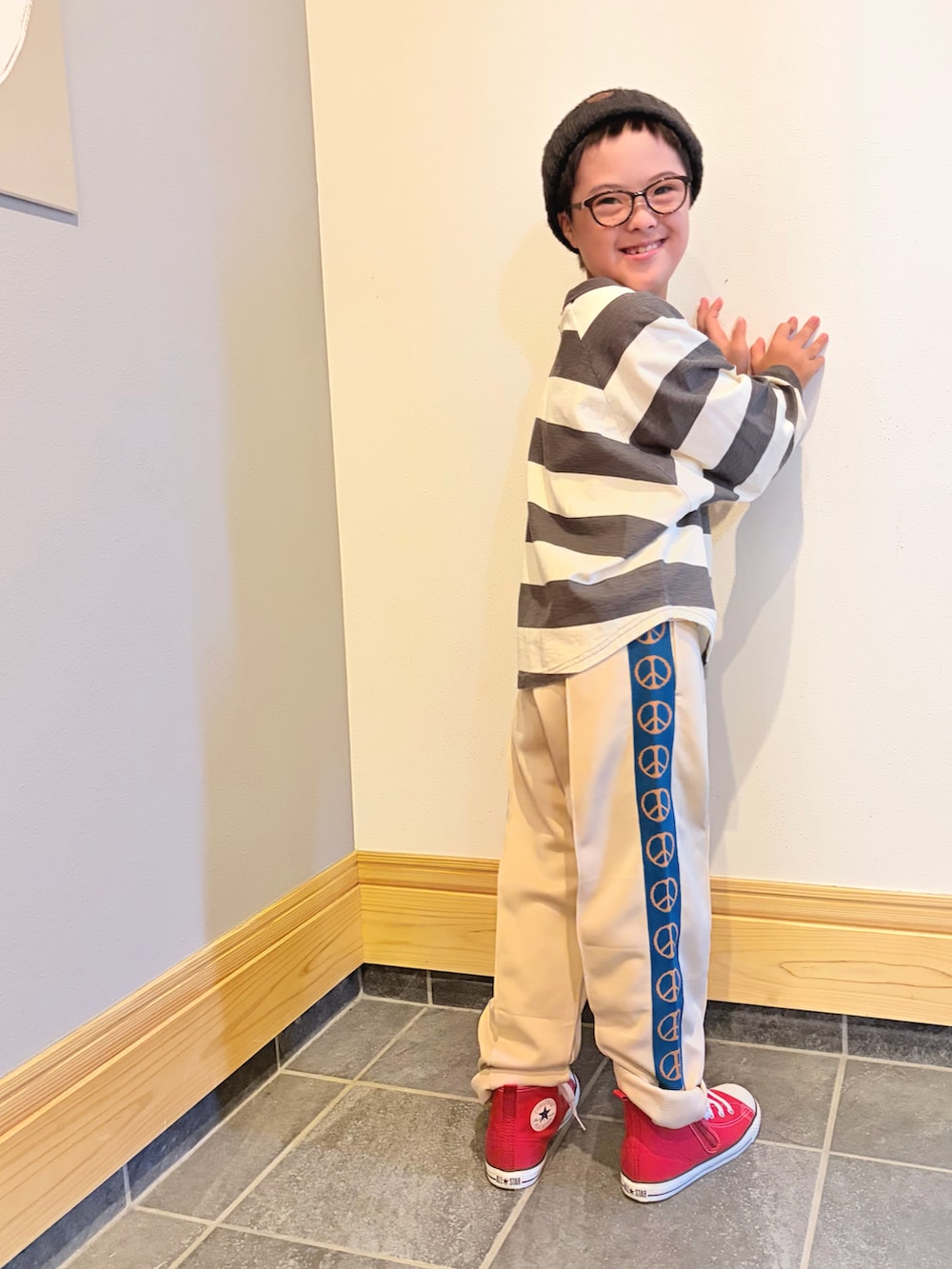 ブラック系のTシャツ/カットソー、ホワイト系のその他パンツ、レッド系のスニーカーを着用したキッズの秋コーディネートの2枚目の写真