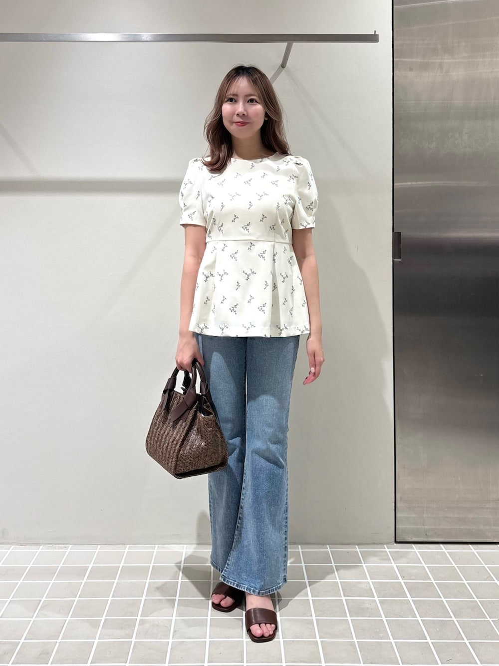 ホワイト系のシャツ/ブラウス、ブルー系のデニムパンツ、ブラウン系のトートバッグを着用したレディースの夏コーディネートの2枚目の写真