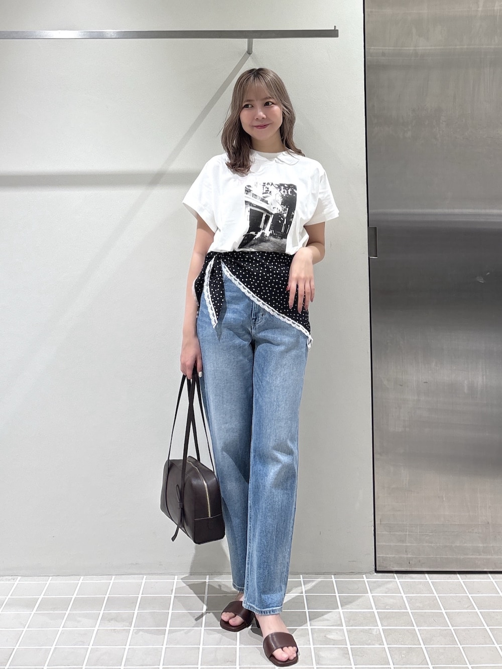 ホワイト系のTシャツ/カットソー、ブルー系のデニムパンツ、ブラウン系のボストンバッグを着用したレディースの夏コーディネートの4枚目の写真