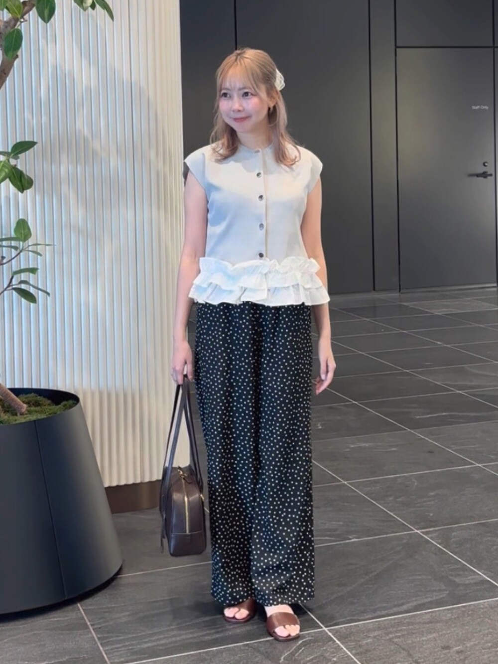 グレー系のベスト、ブラック系のその他パンツ、ブラウン系のサンダルを着用したレディースの夏コーディネートの5枚目の写真