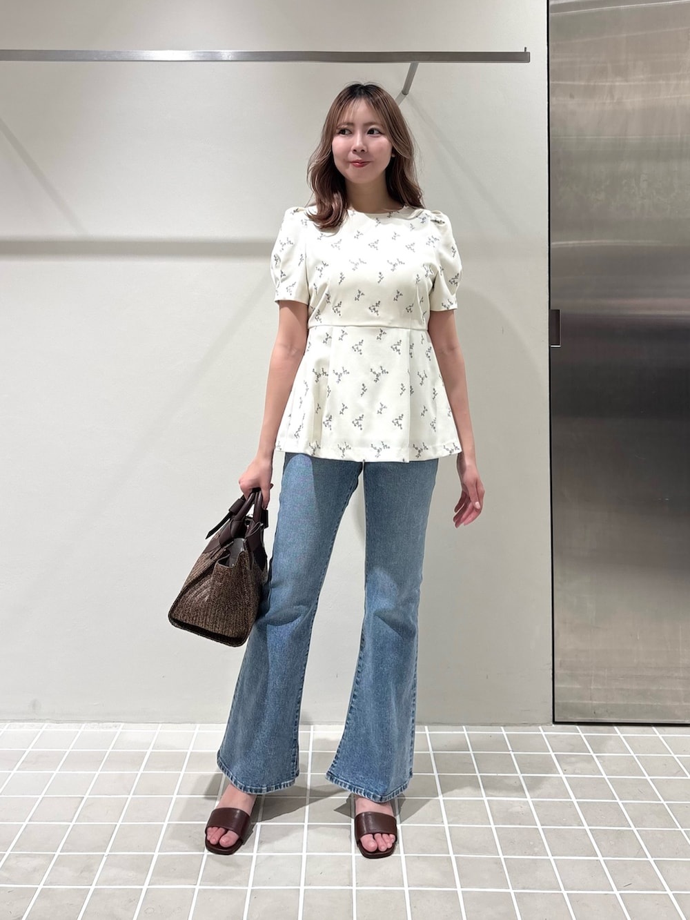 ホワイト系のシャツ/ブラウス、ブルー系のデニムパンツ、ブラウン系のトートバッグを着用したレディースの夏コーディネートの4枚目の写真