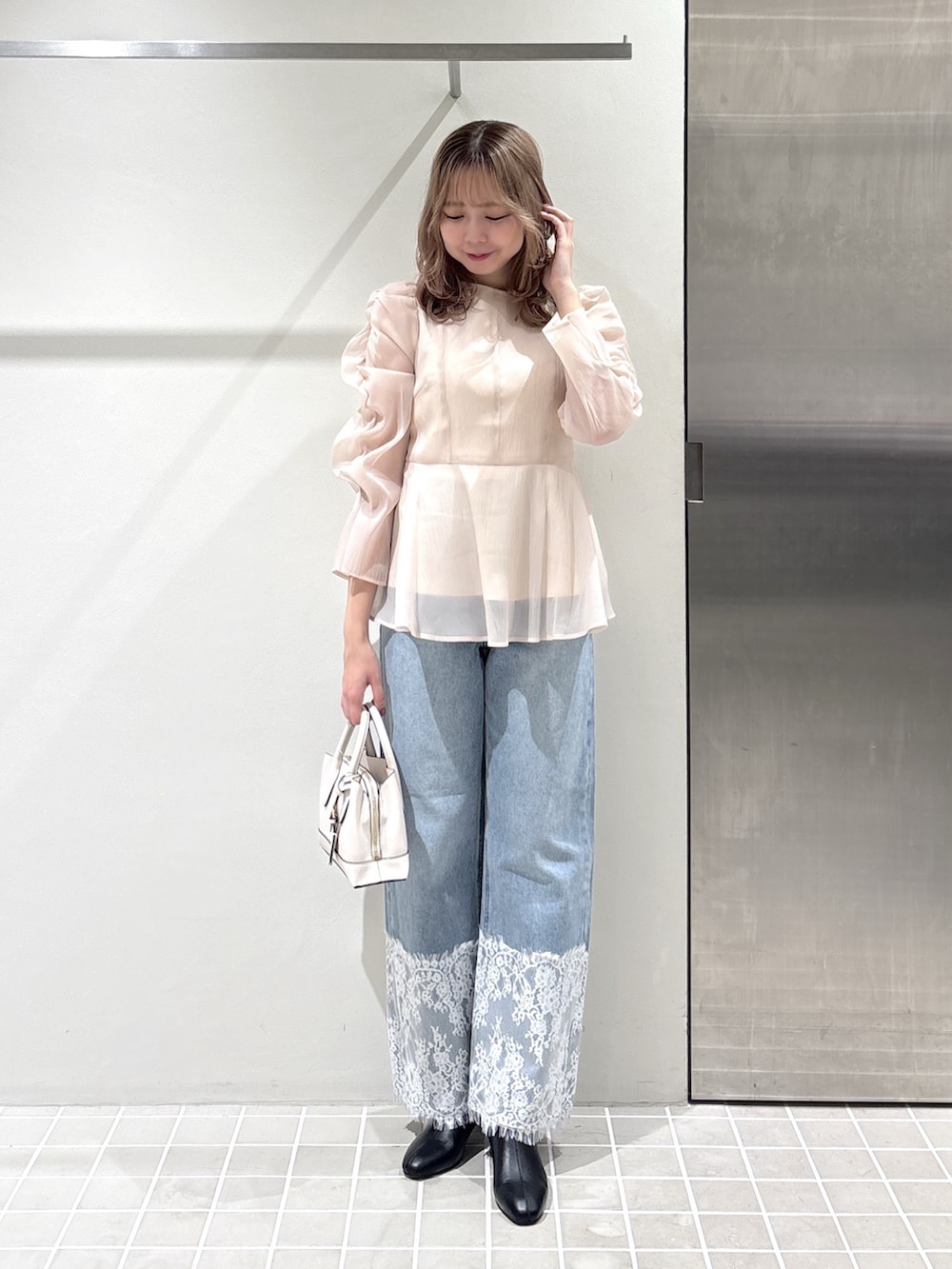 ベージュ系のシャツ/ブラウス、ブルー系のデニムパンツ、ホワイト系のトートバッグを着用したレディースの夏コーディネートの2枚目の写真