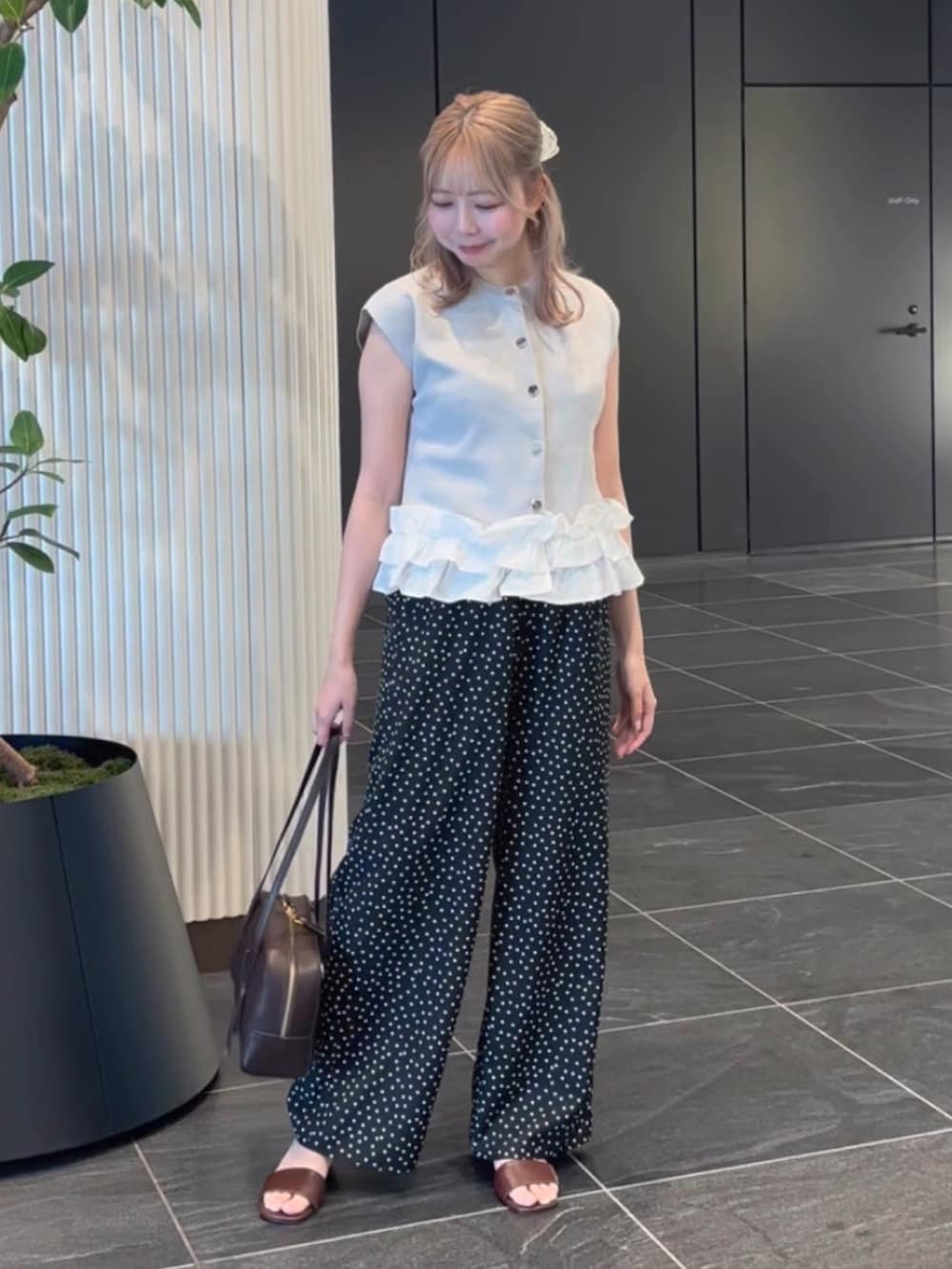 グレー系のベスト、ブラック系のその他パンツ、ブラウン系のサンダルを着用したレディースの夏コーディネートの3枚目の写真